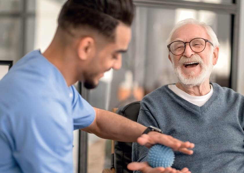 Elderly man and a carer laughing