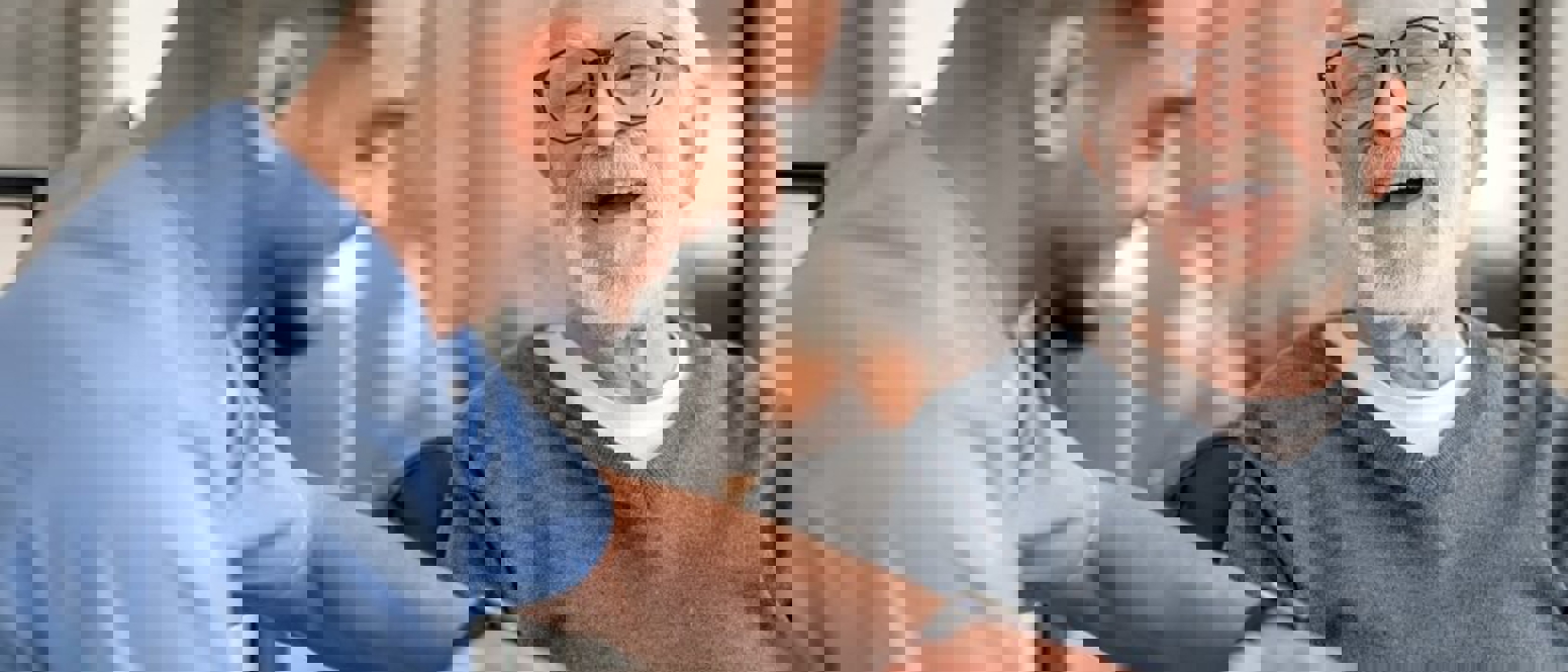 Elderly man and a carer laughing
